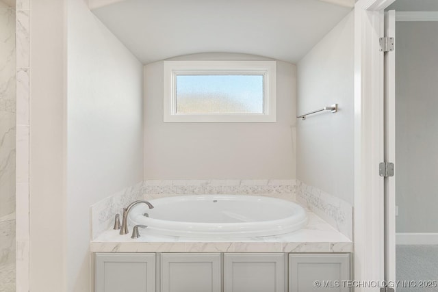 bathroom with a bath, a tile shower, and vaulted ceiling