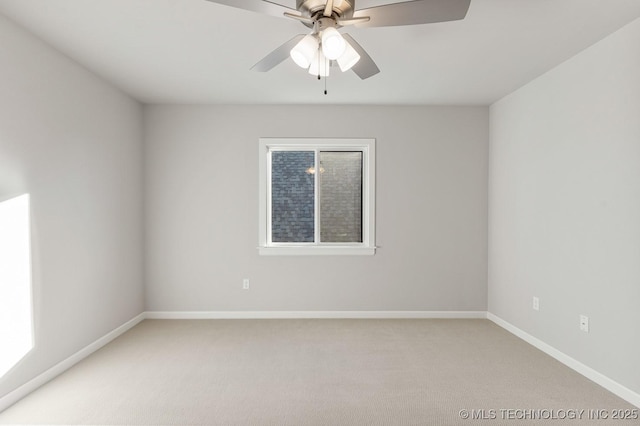 spare room with baseboards, light carpet, and a ceiling fan