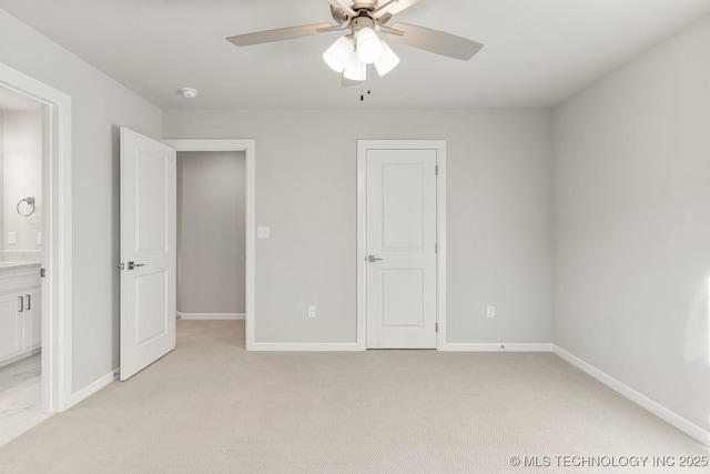 unfurnished bedroom with light colored carpet, a ceiling fan, ensuite bathroom, and baseboards