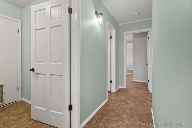 hallway with tile patterned flooring and baseboards