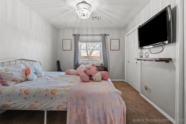 carpeted bedroom with visible vents, a notable chandelier, a textured ceiling, a closet, and baseboards