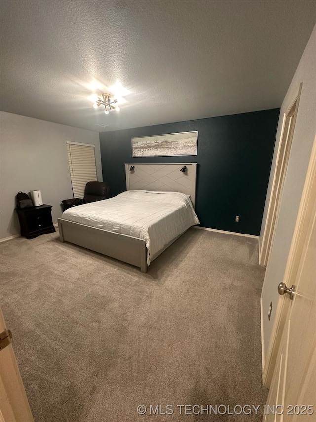 bedroom with baseboards, carpet floors, and a textured ceiling