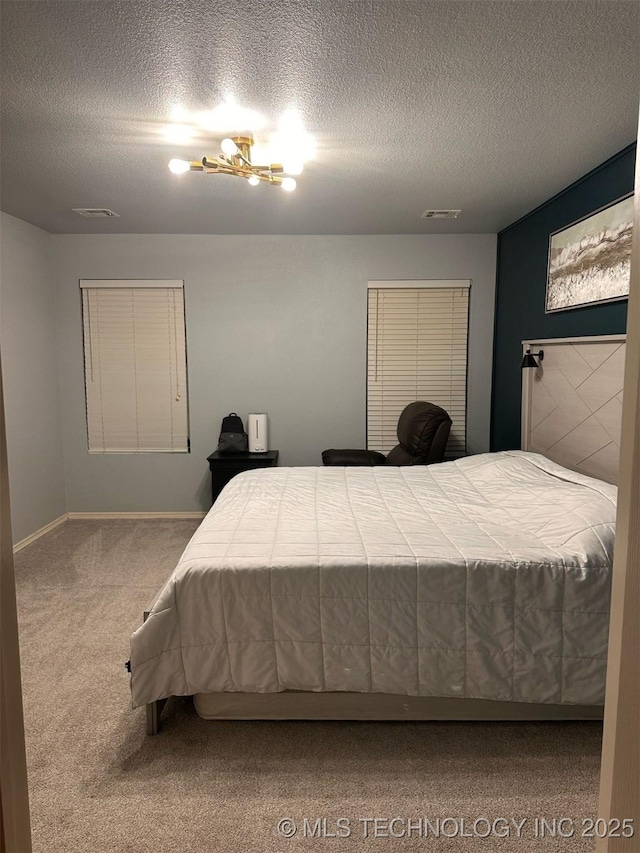 bedroom with carpet flooring, visible vents, and a textured ceiling