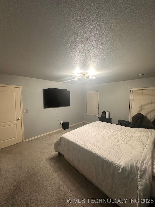 bedroom with visible vents, a textured ceiling, baseboards, and carpet floors