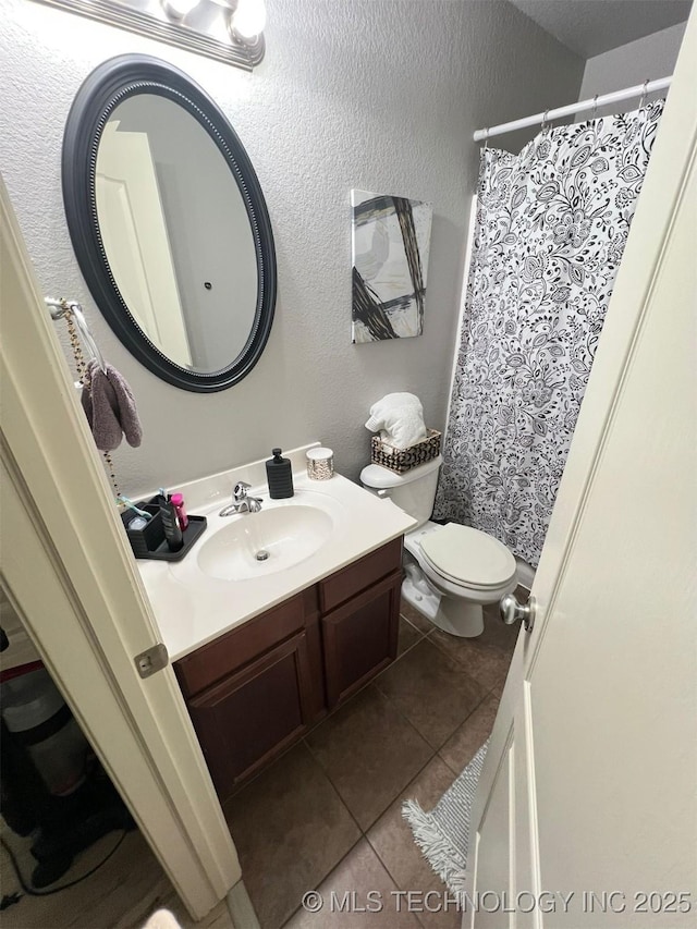 bathroom with a shower with curtain, toilet, tile patterned flooring, vanity, and a textured wall