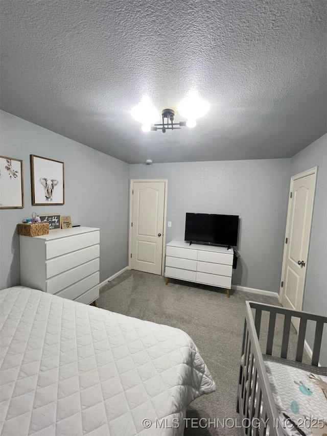 bedroom with baseboards, carpet, and a textured ceiling