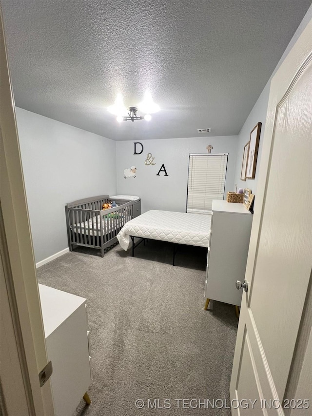 bedroom with carpet flooring, visible vents, and a textured ceiling