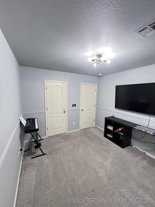 interior space with baseboards, visible vents, a textured ceiling, and carpet