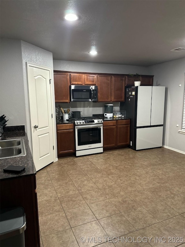 kitchen with visible vents, recessed lighting, a sink, appliances with stainless steel finishes, and dark countertops