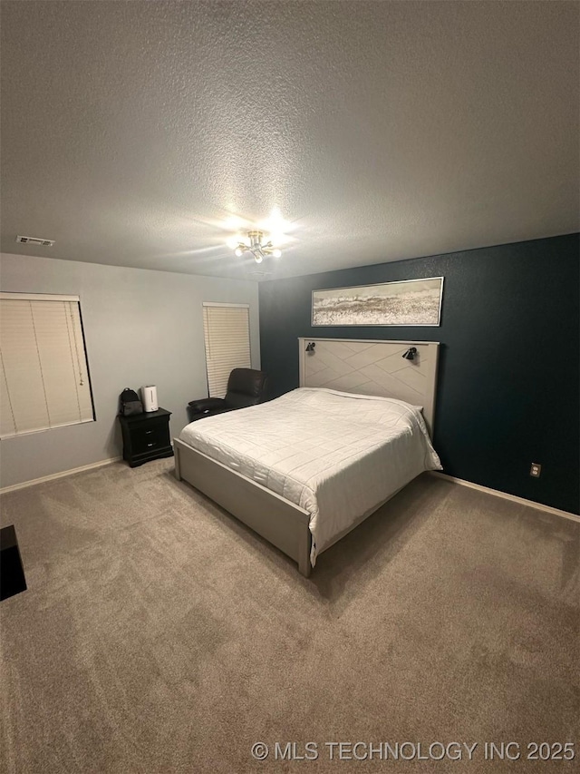 bedroom featuring visible vents, carpet, and a textured ceiling