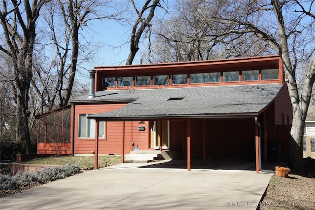 view of front of house featuring driveway and roof with shingles