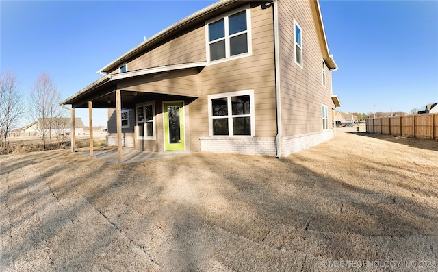 rear view of house featuring fence