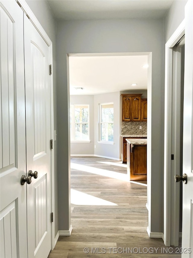 hallway with baseboards and light wood finished floors