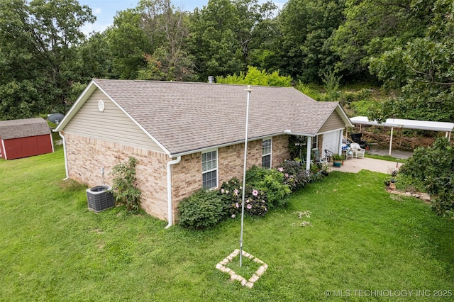 exterior space with central air condition unit, a yard, a storage shed, an outdoor structure, and brick siding