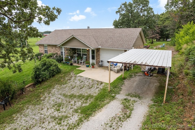 back of property with brick siding, driveway, and roof with shingles