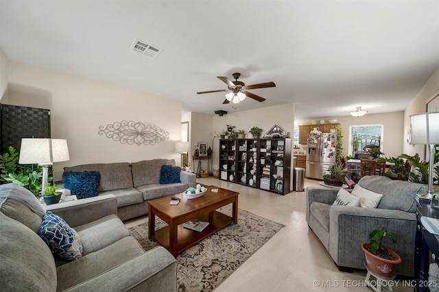 living room featuring a ceiling fan, visible vents, and concrete floors