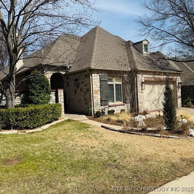 french provincial home featuring a front lawn, an attached garage, stone siding, and a shingled roof