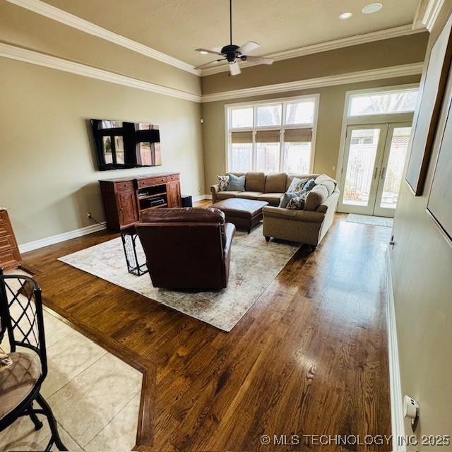 living room with french doors, crown molding, and wood finished floors