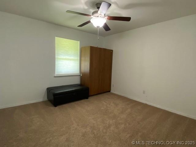 spare room featuring light carpet and ceiling fan