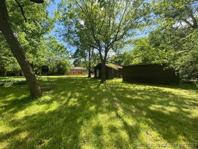 view of yard featuring a storage shed and an outdoor structure