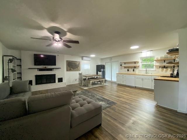 living room with dark wood-style floors, recessed lighting, a fireplace, and ceiling fan