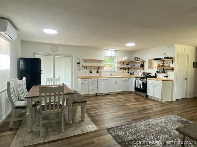 kitchen featuring open shelves, a wall mounted air conditioner, dark wood-type flooring, and white appliances