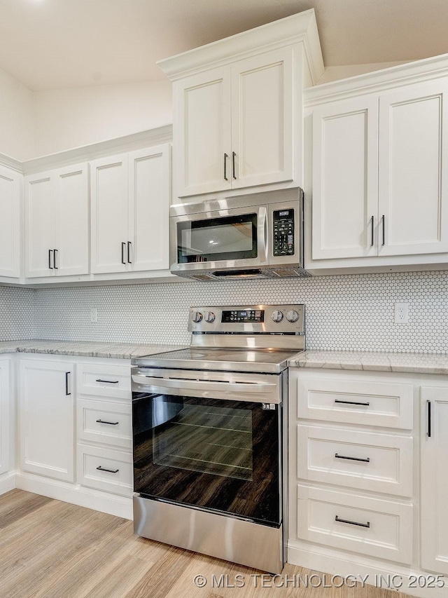 kitchen with white cabinets, backsplash, light wood finished floors, and stainless steel appliances