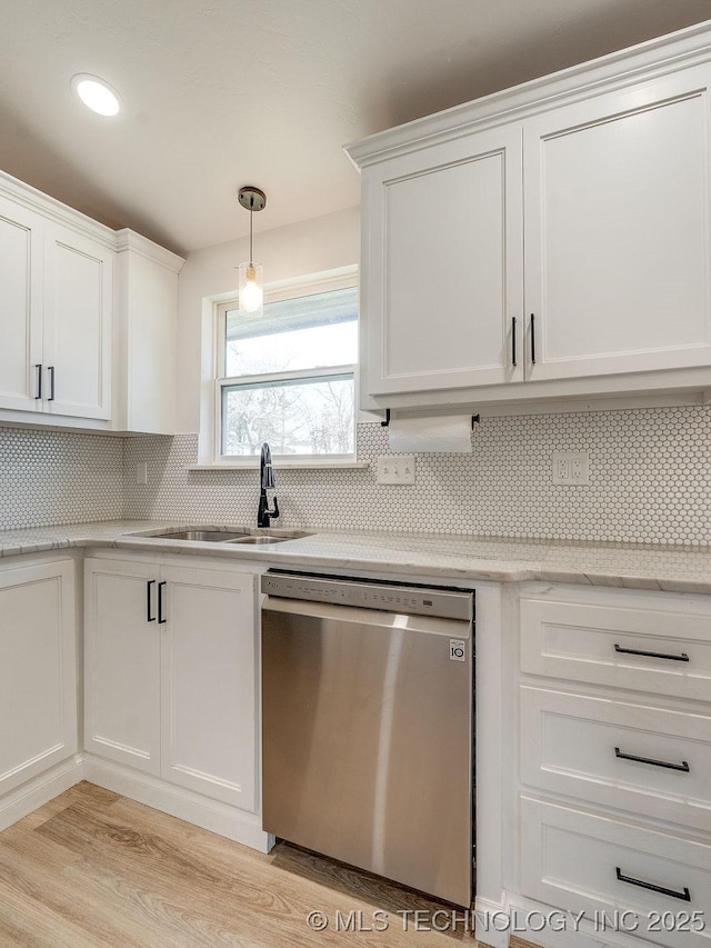 kitchen with tasteful backsplash, a sink, white cabinets, and stainless steel dishwasher