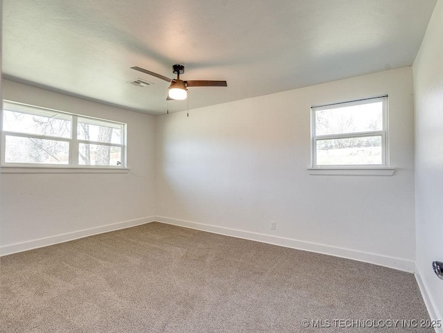 spare room with plenty of natural light, a ceiling fan, baseboards, and carpet floors