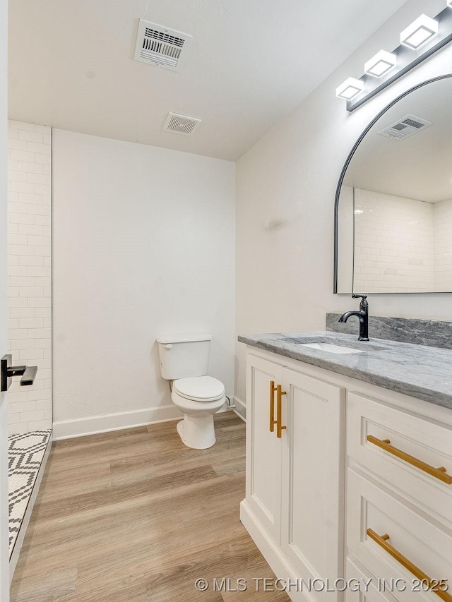 full bathroom featuring vanity, toilet, wood finished floors, and visible vents