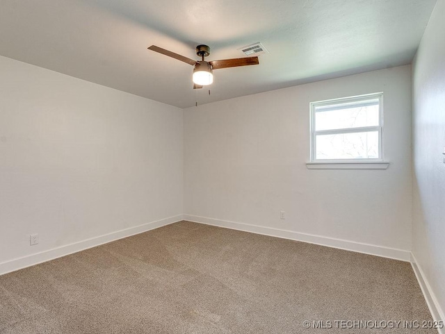 spare room with visible vents, carpet floors, baseboards, and ceiling fan