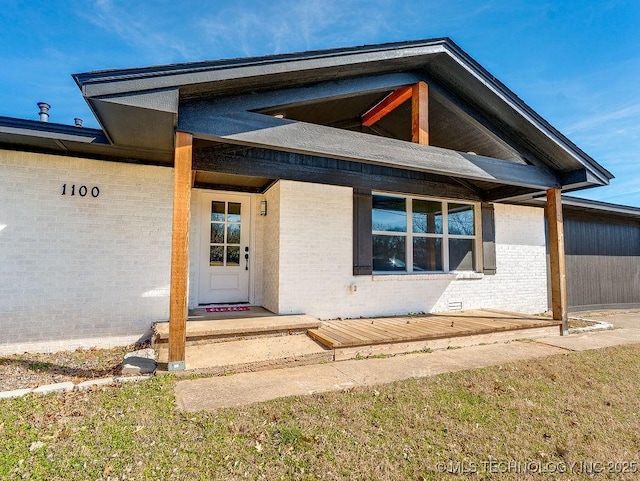 view of exterior entry featuring brick siding