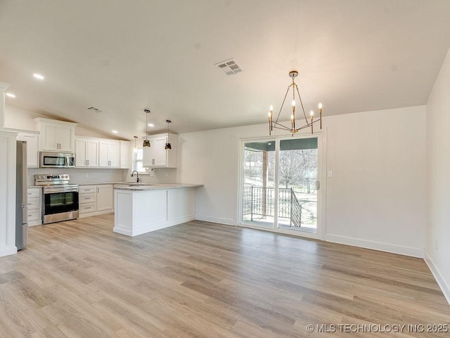 kitchen with visible vents, lofted ceiling, light countertops, appliances with stainless steel finishes, and open floor plan