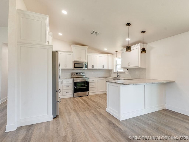 kitchen featuring visible vents, backsplash, stainless steel appliances, a peninsula, and lofted ceiling