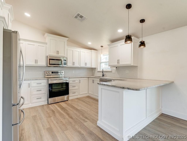 kitchen with visible vents, a sink, tasteful backsplash, appliances with stainless steel finishes, and a peninsula
