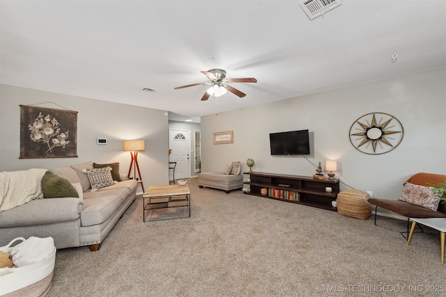 living area featuring carpet flooring, visible vents, and ceiling fan