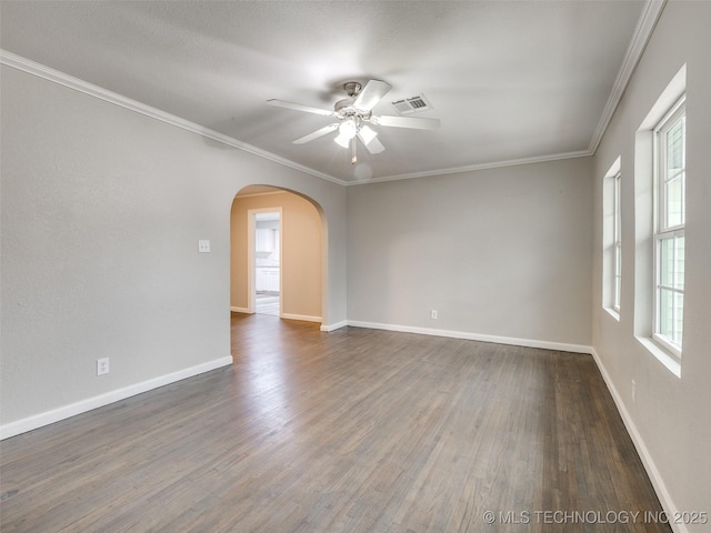 spare room featuring visible vents, crown molding, dark wood-type flooring, baseboards, and arched walkways