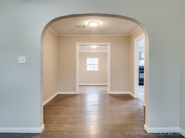 interior space with arched walkways, visible vents, wood finished floors, and ornamental molding