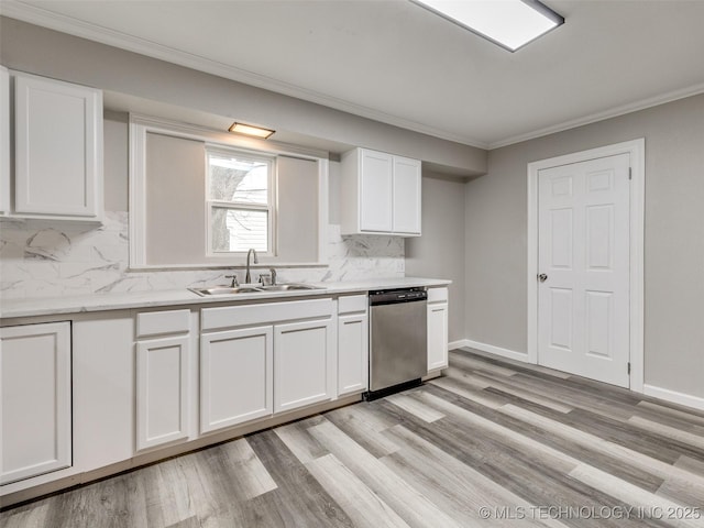 kitchen featuring stainless steel dishwasher, white cabinets, ornamental molding, and a sink