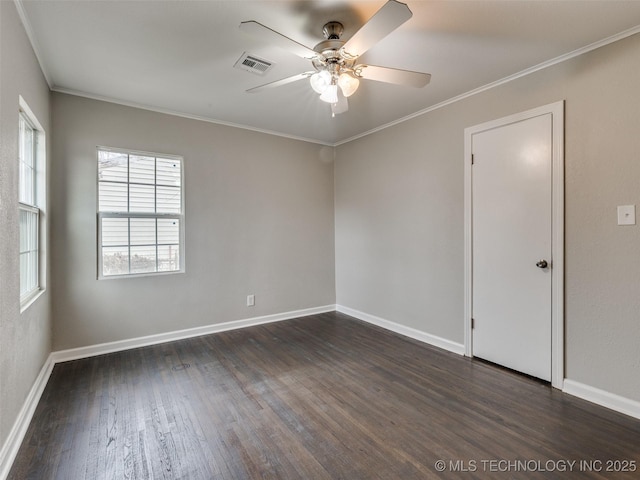 empty room with dark wood-type flooring, baseboards, visible vents, and ornamental molding