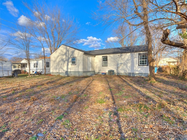 back of house featuring central AC unit and fence