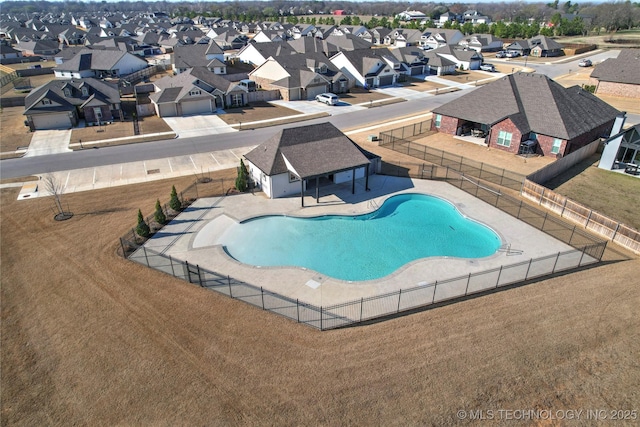 community pool featuring a patio area, fence, and a residential view