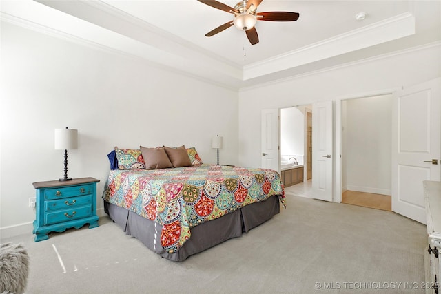 bedroom featuring carpet, a ceiling fan, ensuite bath, crown molding, and a raised ceiling