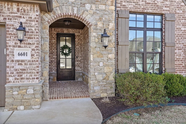 property entrance with brick siding and stone siding