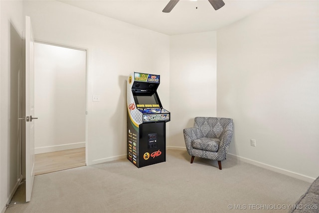 living area with baseboards, ceiling fan, and carpet floors