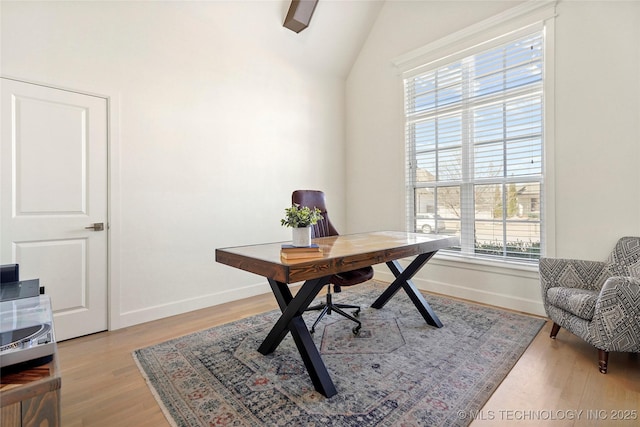 home office with vaulted ceiling, baseboards, and light wood-type flooring