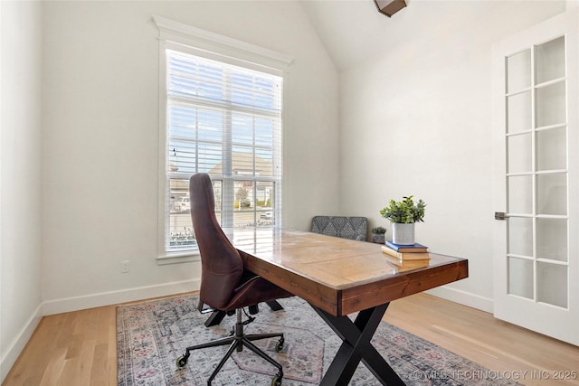 home office with vaulted ceiling, baseboards, and light wood finished floors