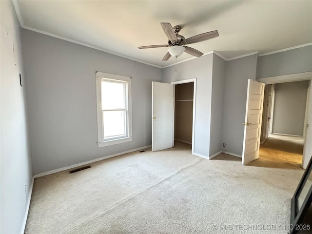 unfurnished bedroom with visible vents, carpet, crown molding, and baseboards