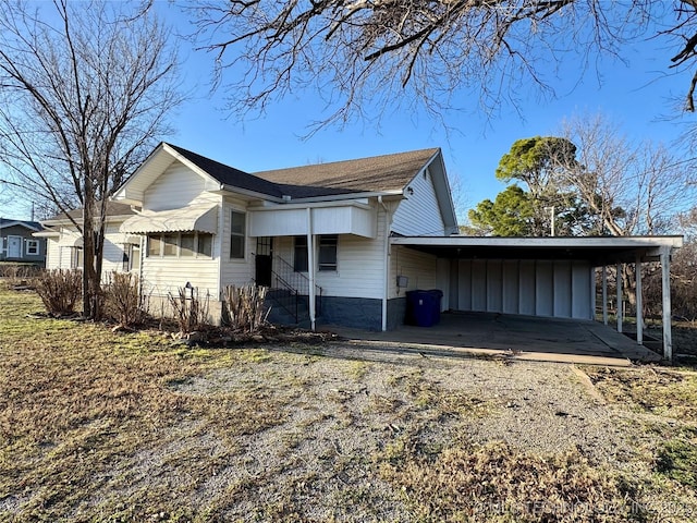 view of property exterior featuring an attached carport and driveway