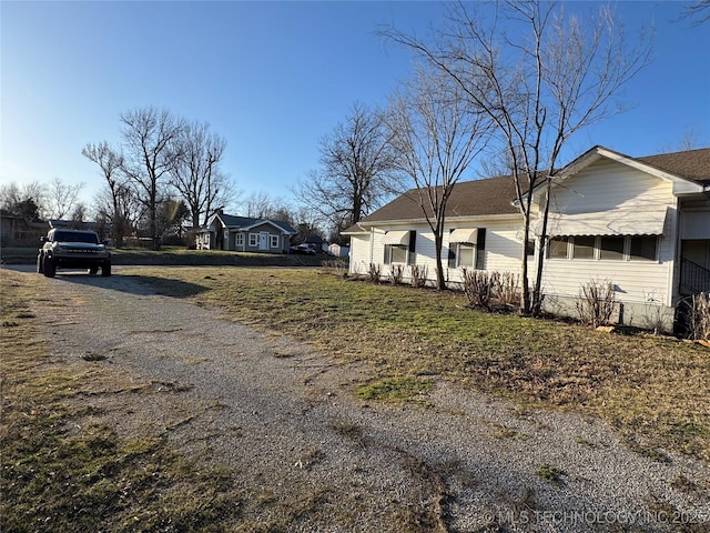 view of side of property featuring a yard and driveway